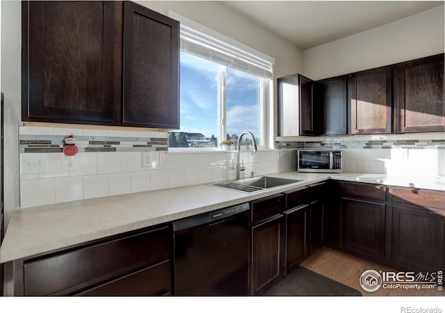 kitchen with black dishwasher, tasteful backsplash, stainless steel microwave, a sink, and dark brown cabinetry