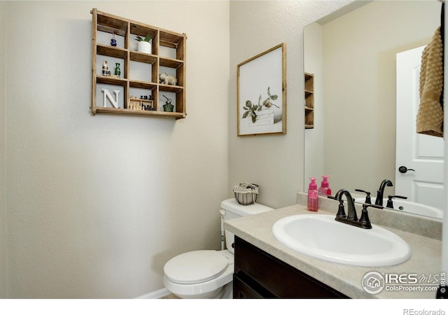 half bathroom with toilet and vanity