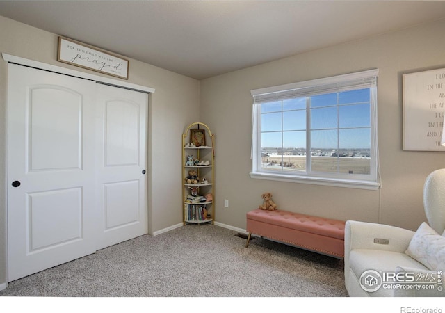 sitting room featuring carpet flooring and baseboards