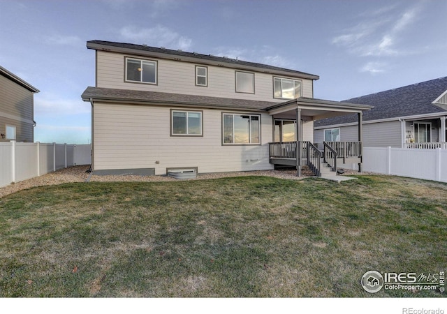 rear view of house with a fenced backyard and a yard