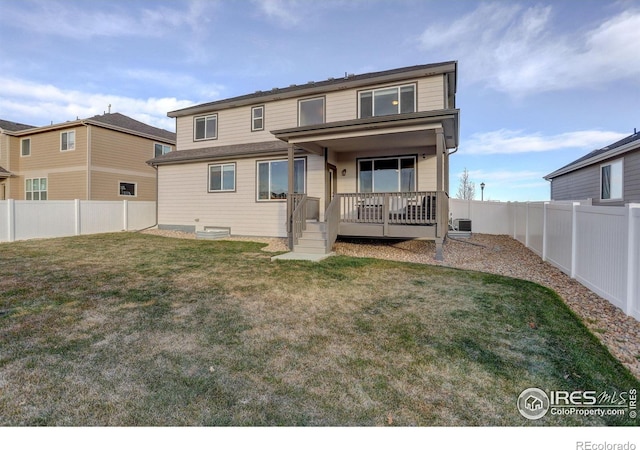 back of property with a fenced backyard, cooling unit, and a yard