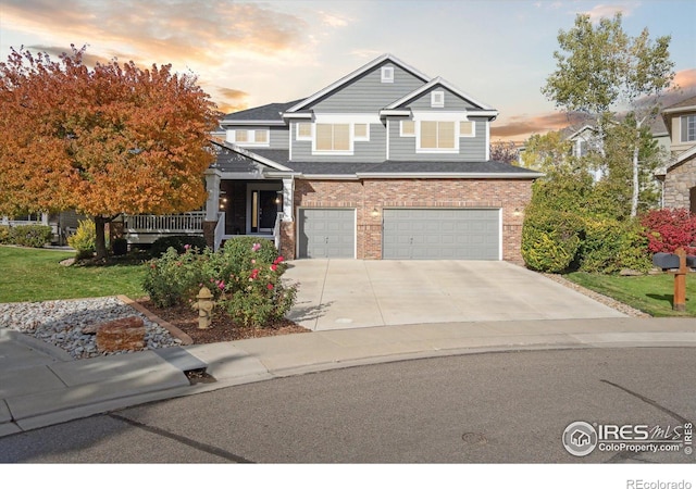 view of front of house featuring an attached garage, brick siding, and driveway