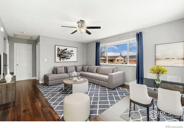 living room with ceiling fan, attic access, baseboards, and wood finished floors