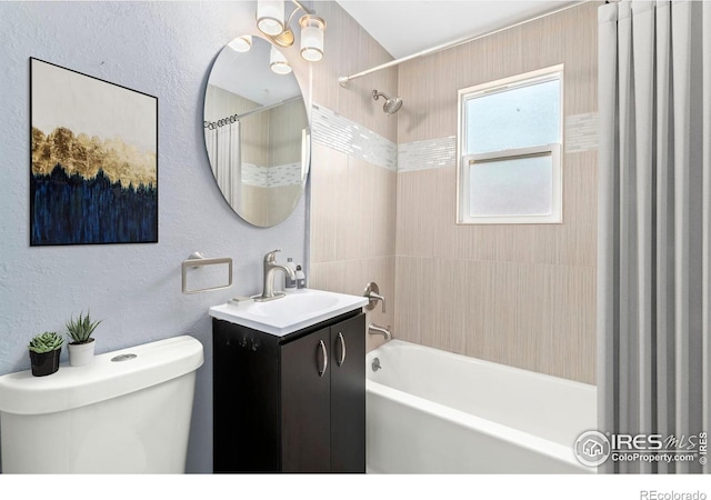 bathroom featuring vanity, toilet, shower / bath combo with shower curtain, and a textured wall