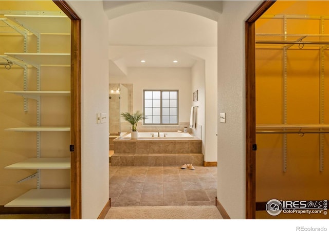 bathroom featuring a bath and baseboards