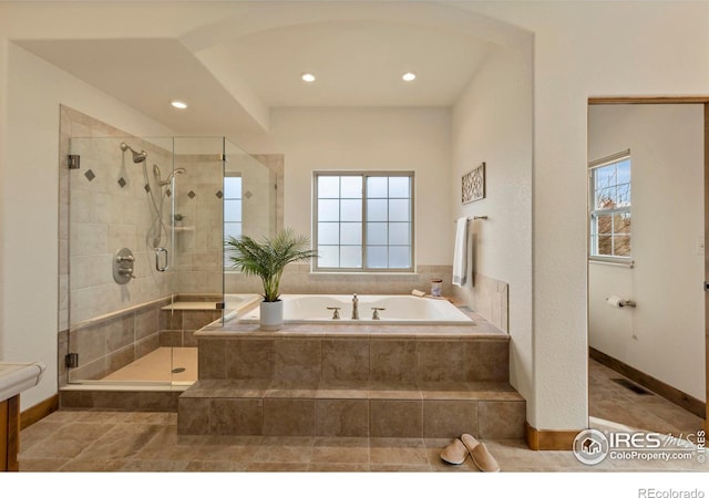 bathroom with visible vents, a healthy amount of sunlight, a bath, and a shower stall