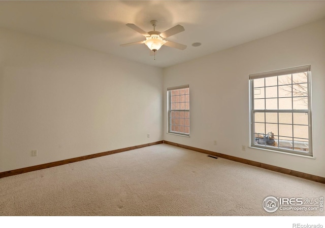 unfurnished room featuring visible vents, baseboards, a ceiling fan, and carpet floors