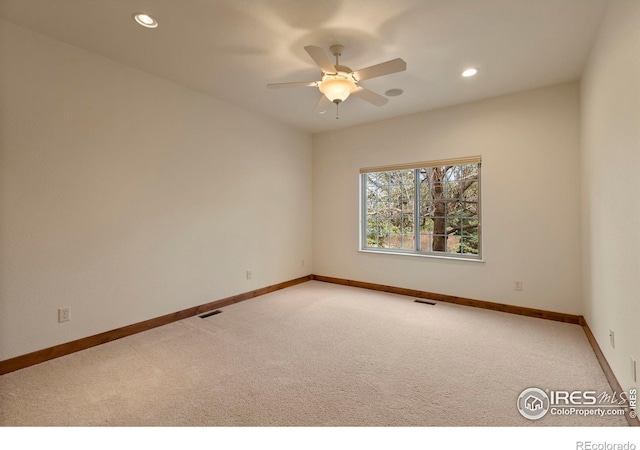 spare room with visible vents, light carpet, and baseboards