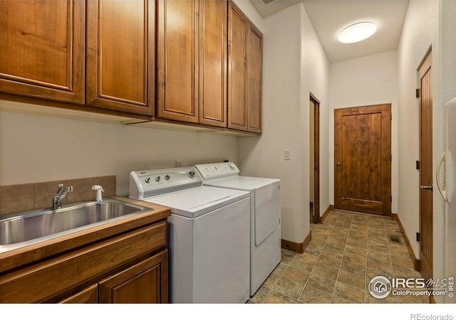 laundry room with visible vents, baseboards, cabinet space, a sink, and washing machine and dryer