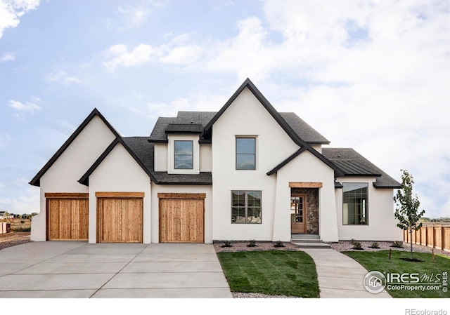 view of front of home featuring metal roof, concrete driveway, a standing seam roof, and fence