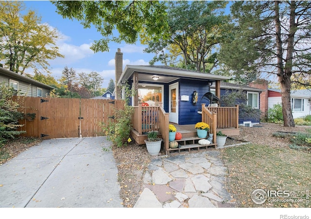 exterior space with a chimney, fence, and a gate