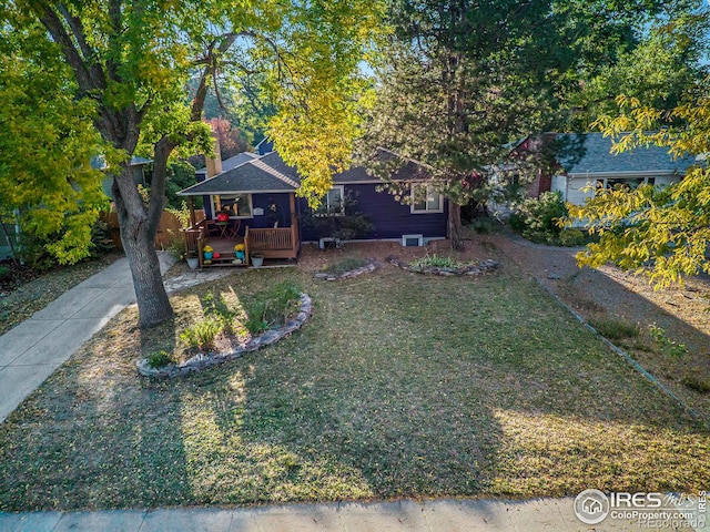 view of front of home with a wooden deck and a front yard