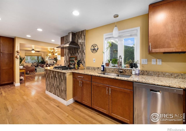 kitchen featuring light wood-style flooring, recessed lighting, a sink, stainless steel appliances, and brown cabinets