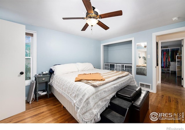 bedroom featuring visible vents, a ceiling fan, and wood finished floors