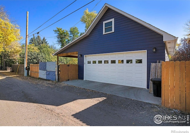 detached garage featuring fence