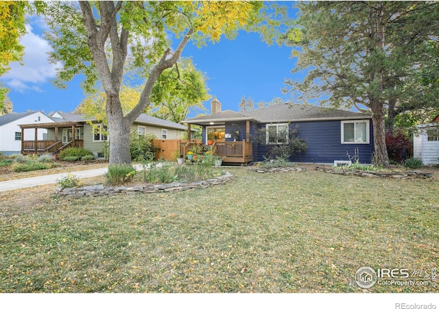 single story home with a chimney, a wooden deck, and a front yard