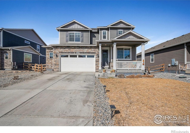 craftsman house featuring driveway, stone siding, covered porch, board and batten siding, and an attached garage