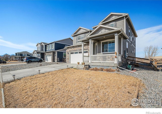 view of front of house featuring driveway, stone siding, covered porch, board and batten siding, and a garage