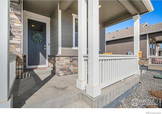 entrance to property with stone siding and covered porch