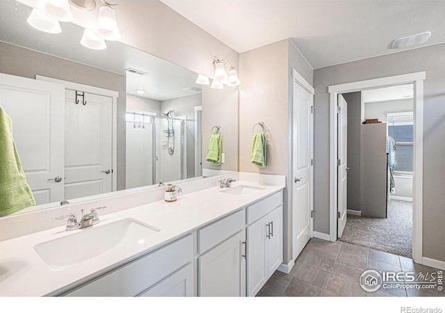 full bathroom with double vanity, visible vents, a stall shower, and a sink