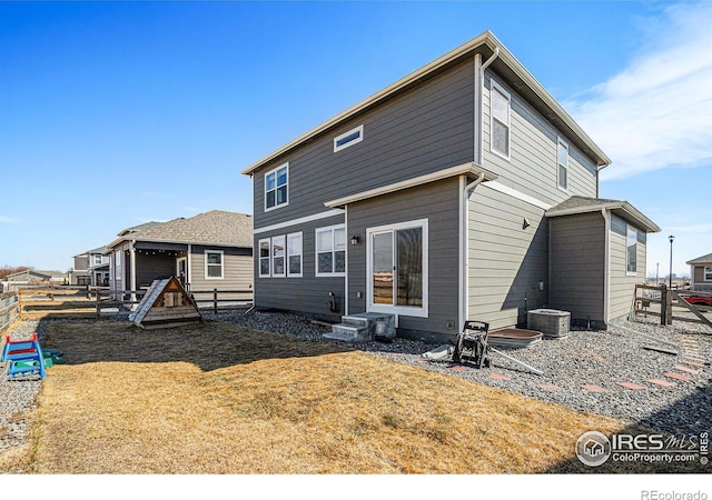 back of house with a yard, central AC unit, and fence