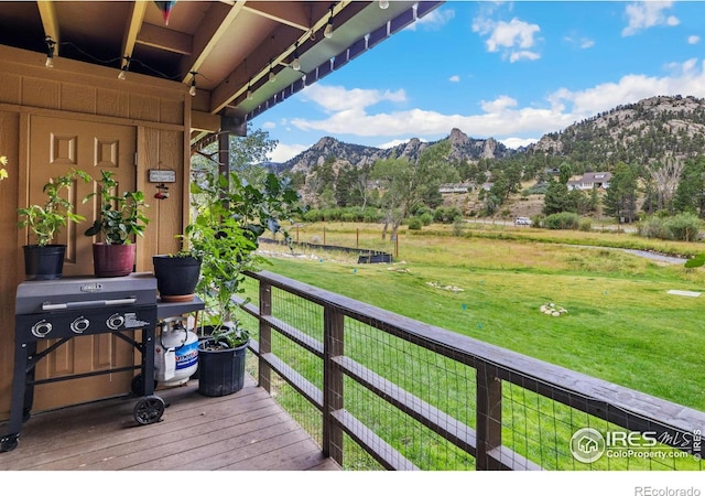 deck with a mountain view and a lawn