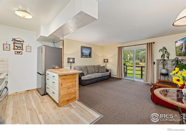 living area with light carpet, light wood-style flooring, baseboards, and a baseboard radiator