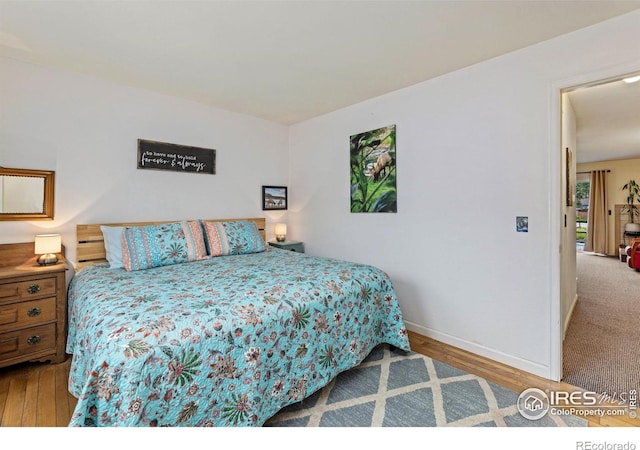 bedroom featuring wood finished floors and baseboards