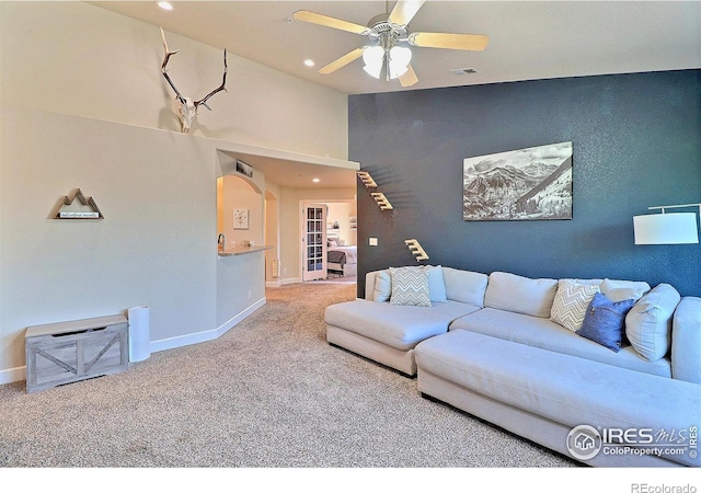 living room with a ceiling fan, visible vents, baseboards, and carpet floors