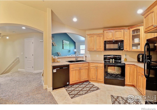 kitchen with black appliances, a sink, arched walkways, light countertops, and glass insert cabinets