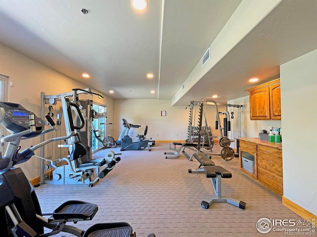 exercise room with recessed lighting, baseboards, visible vents, and light carpet