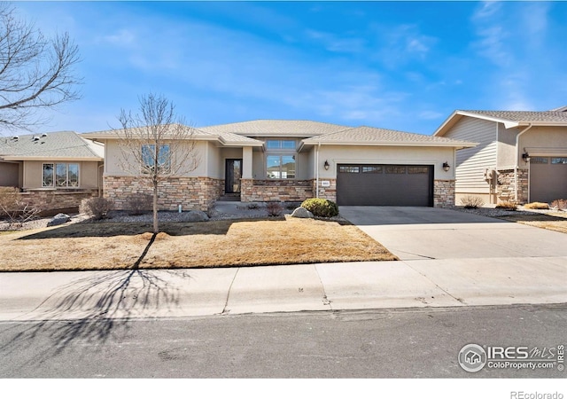 view of front facade featuring stucco siding, stone siding, concrete driveway, and an attached garage