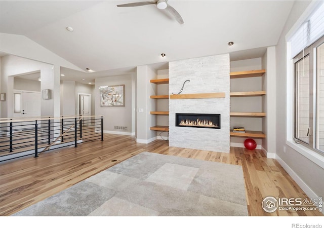 living area with visible vents, built in shelves, wood finished floors, and vaulted ceiling