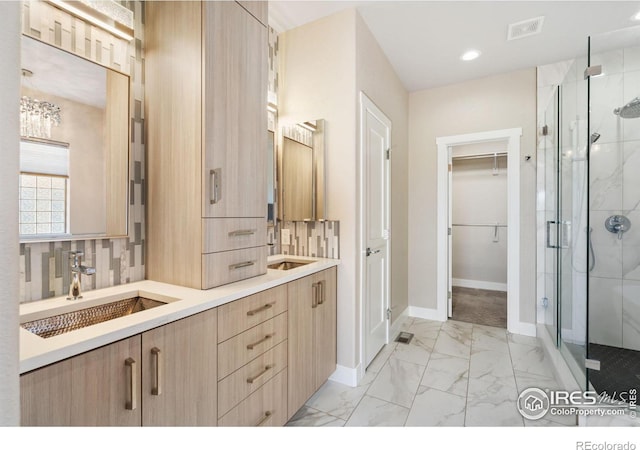 bathroom with a sink, visible vents, marble finish floor, and a stall shower