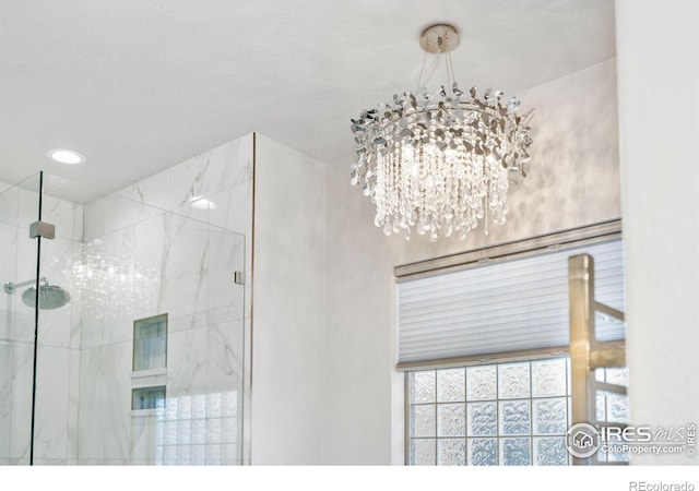 interior space featuring a marble finish shower and an inviting chandelier