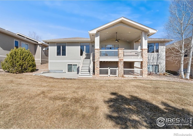 rear view of house with ceiling fan, stairway, a wooden deck, a lawn, and a patio