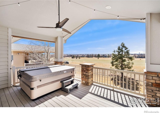 wooden terrace with a ceiling fan and a hot tub