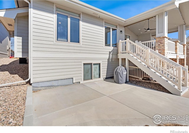 rear view of property featuring a patio and stairway