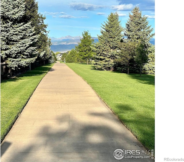 view of property's community with a yard and a mountain view