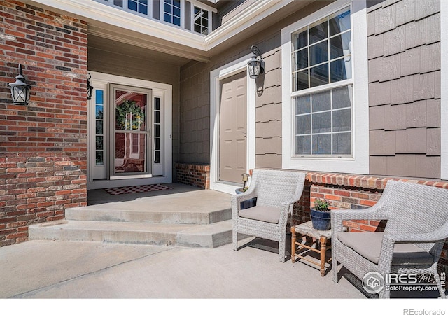 view of exterior entry featuring brick siding