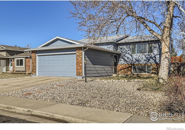 tri-level home with brick siding, an attached garage, and concrete driveway