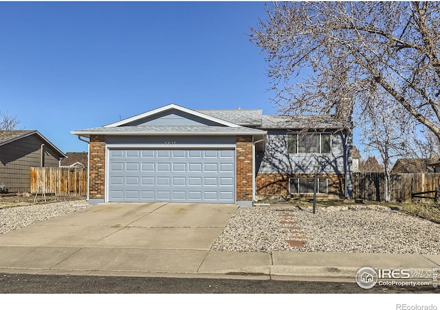 view of front of property with a garage, fence, brick siding, and driveway