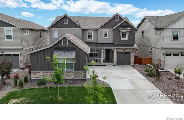 craftsman house featuring driveway, a standing seam roof, a garage, stone siding, and board and batten siding