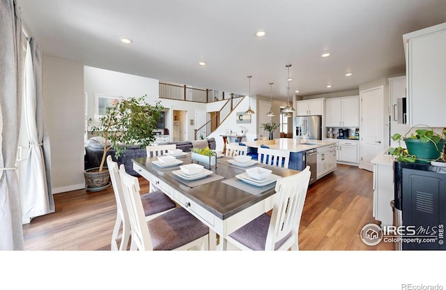 890 Meadowlark Dr, Erie, CO 80516 - dining room featuring light wood finished floors, recessed lighting, and stairs