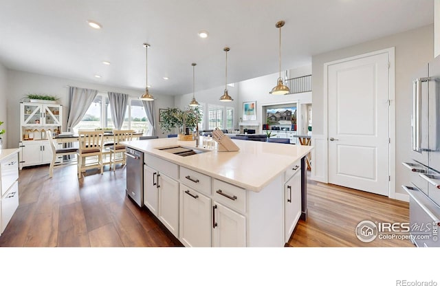 890 Meadowlark Dr, Erie, CO 80516 - kitchen featuring decorative light fixtures, dishwasher, recessed lighting, wood finished floors, and white cabinetry