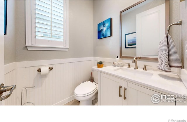 890 Meadowlark Dr, Erie, CO 80516 - bathroom with vanity, toilet, and a wainscoted wall