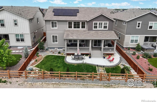 890 Meadowlark Dr, Erie, CO 80516 - rear view of property with a lawn, a patio, roof mounted solar panels, a fenced backyard, and a shingled roof