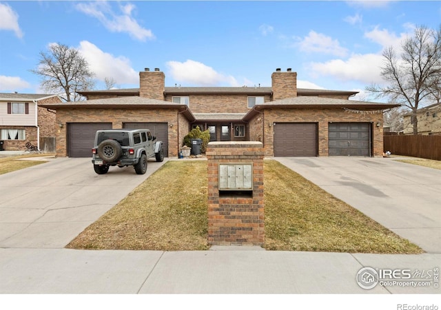 view of front of property with a chimney, concrete driveway, and an attached garage