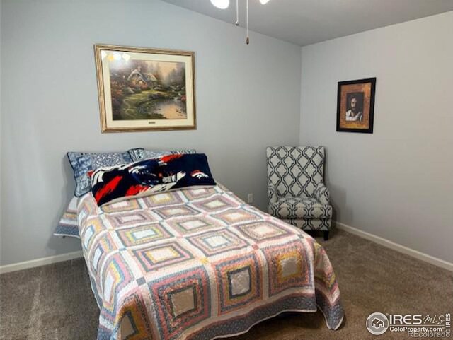 carpeted bedroom featuring baseboards and vaulted ceiling