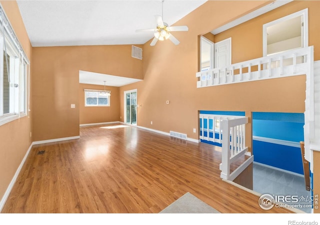 unfurnished living room featuring visible vents, baseboards, and wood finished floors